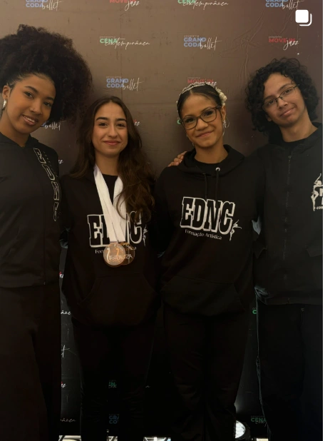 Integrantes da escola usando medalhas em um evento de dança